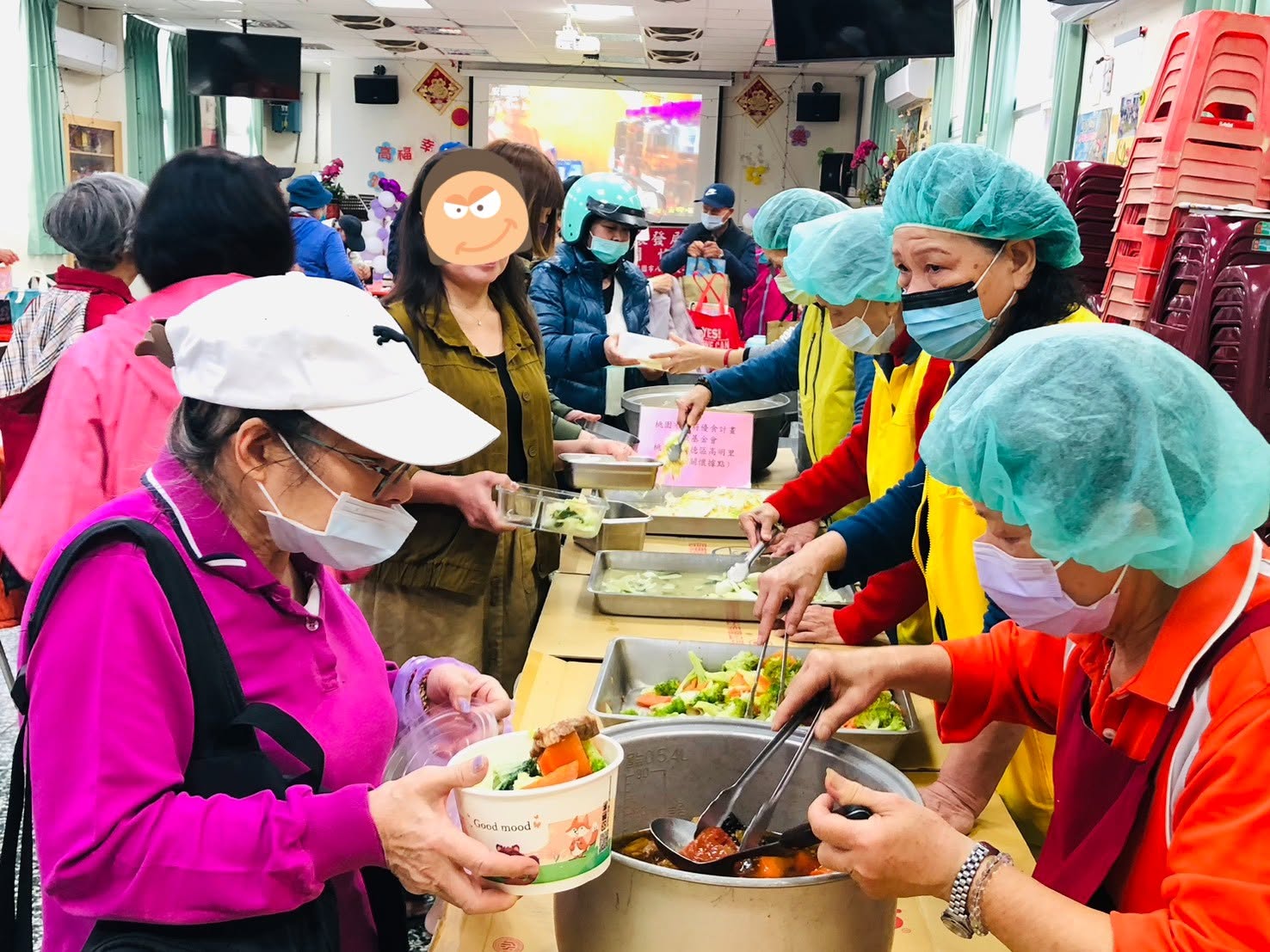 志工在桃園優食計畫現場為民眾盛裝餐食